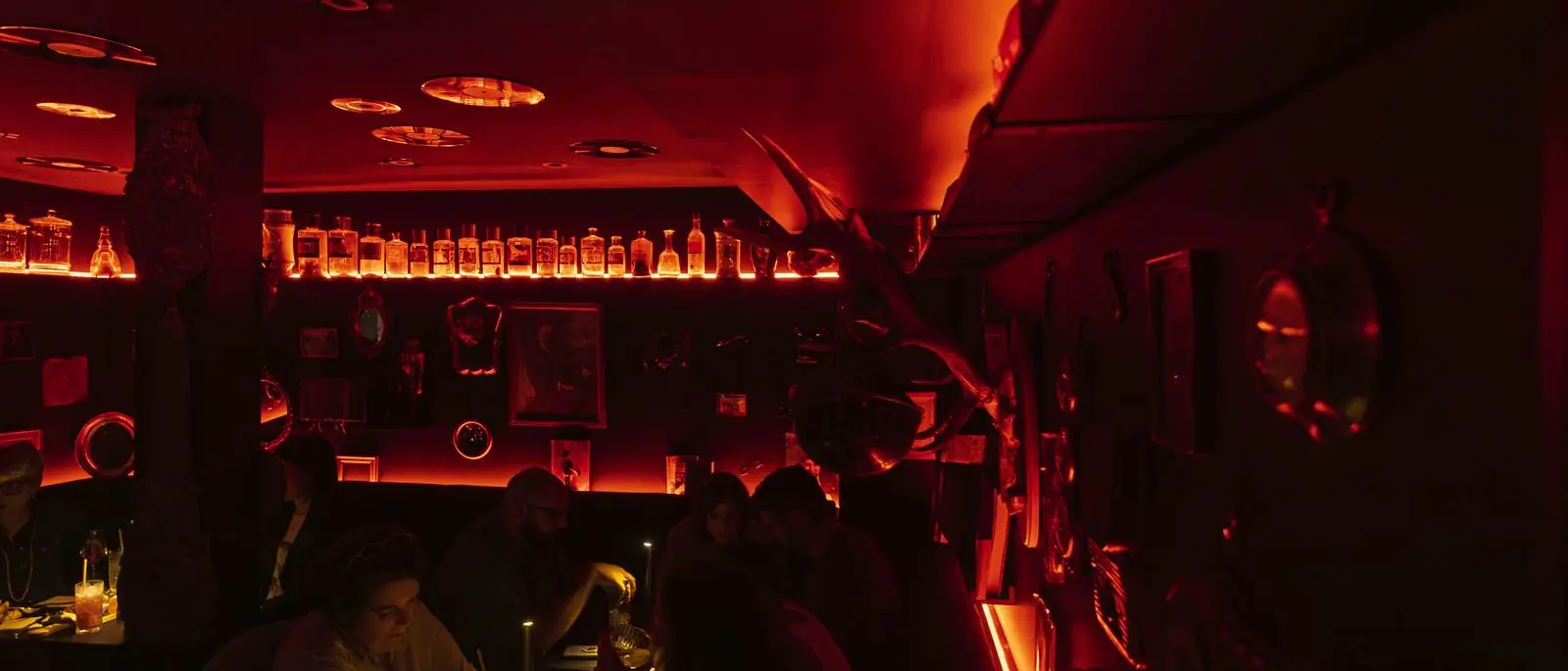 La Crypte, L'Arche's speakeasy bar: a vaulted room bathed in red light, mirrors and backlit bottles