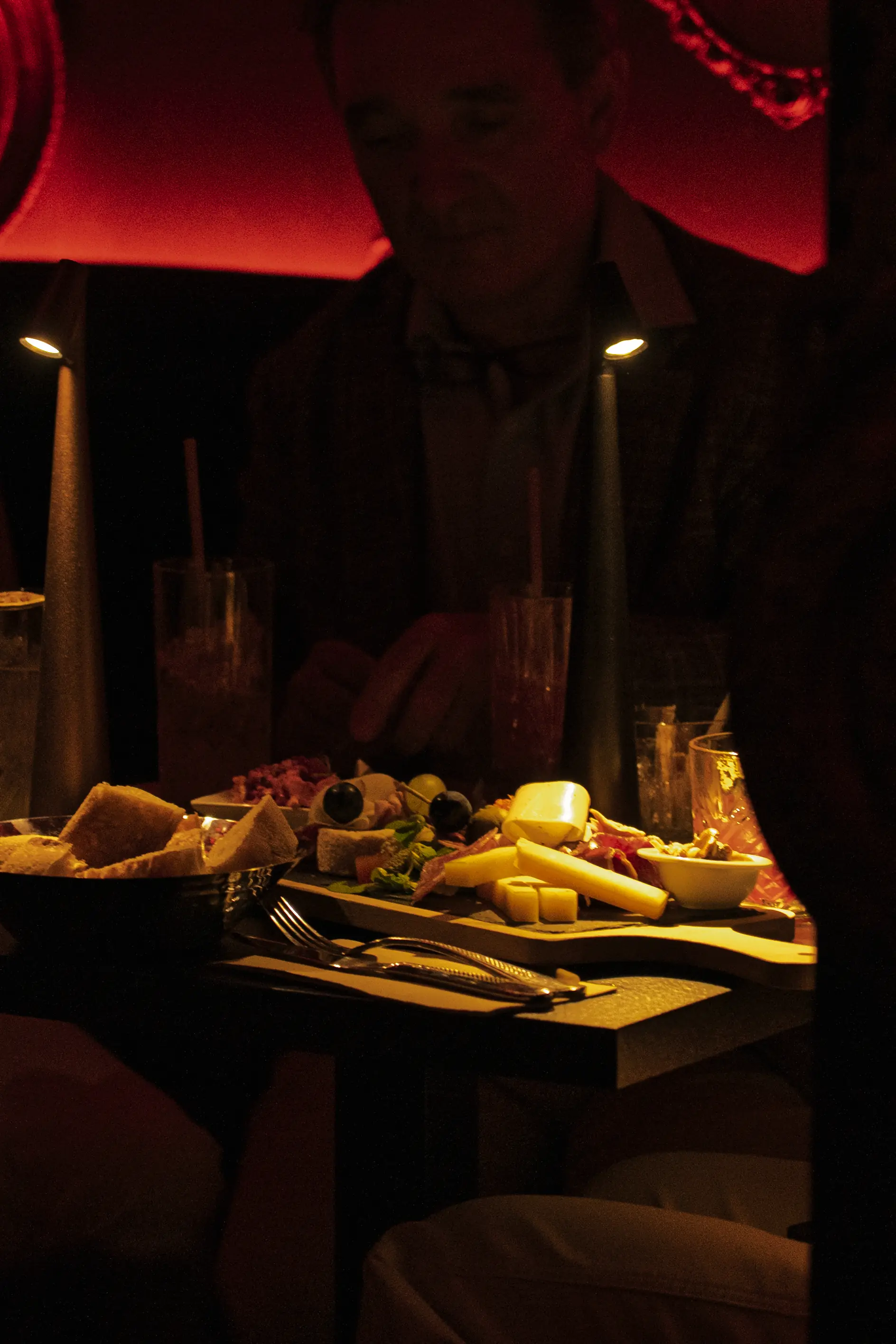 Planche de charcuterie et fromages partagée à La Crypte, cocktails et lampes de table